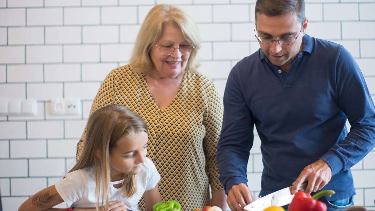 A family happily preparing vegetables together in a modern kitchen.